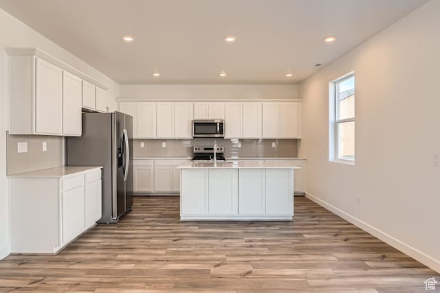 1639 N 800 W, Salem, UT 84653 - kitchen featuring appliances with stainless steel finishes, light countertops, decorative backsplash, white cabinetry, and light wood-style flooring