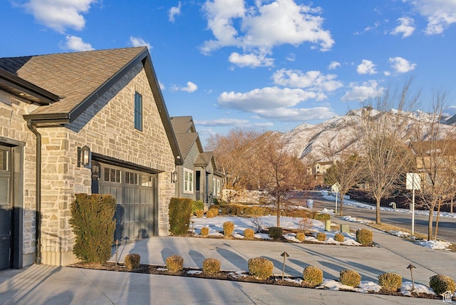 2905 E Denmark Dr, Cottonwood Heights, UT 84121 - exterior space with concrete driveway, stone siding, a shingled roof, a mountain view, and an attached garage