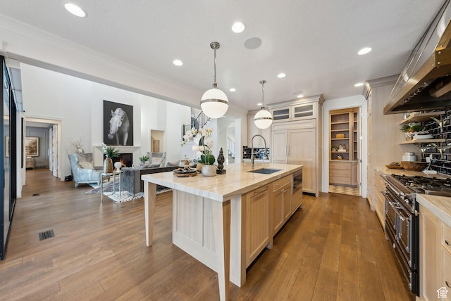 2905 E Denmark Dr, Cottonwood Heights, UT 84121 - kitchen featuring a sink, wall chimney exhaust hood, a breakfast bar, double oven range, and dark wood finished floors