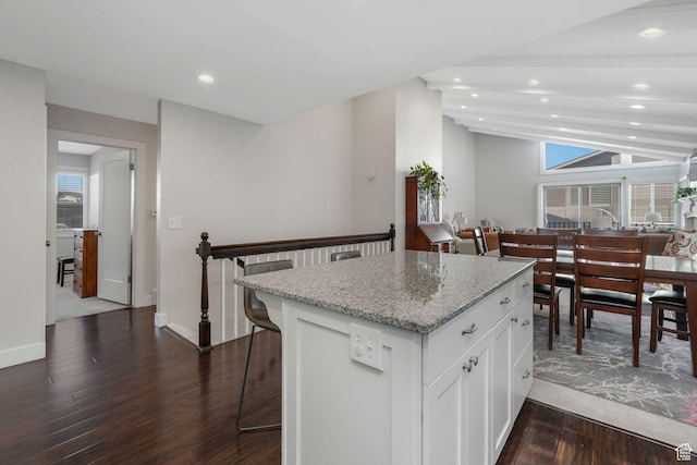 3655 E Oak Rim Way, Millcreek, UT 84109 - kitchen featuring a wealth of natural light, light stone countertops, white cabinets, and a kitchen bar