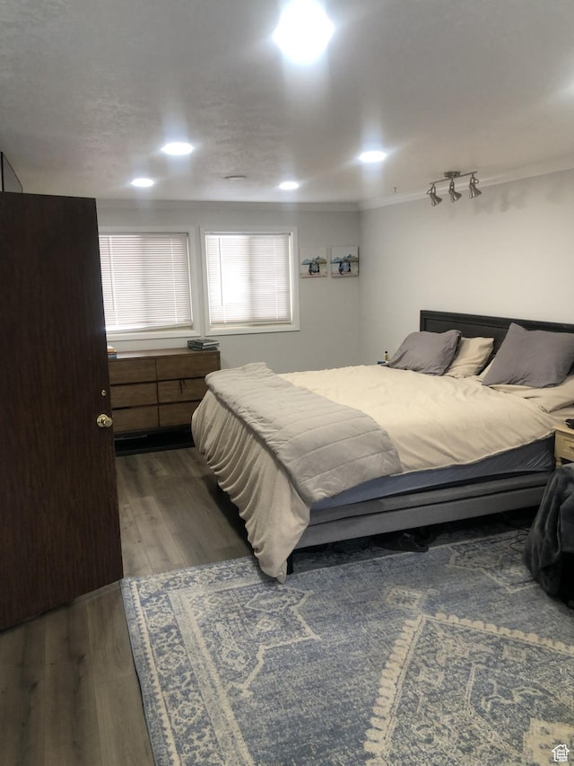 bedroom with dark wood-type flooring and ornamental molding