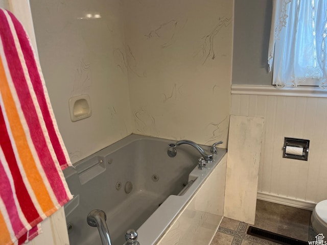 bathroom with a washtub and toilet