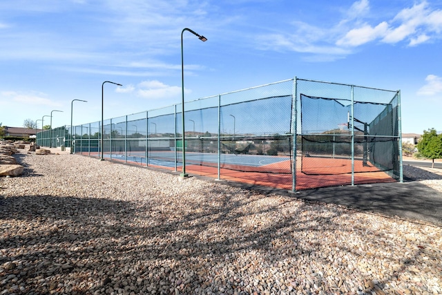 view of tennis court with fence and community basketball court