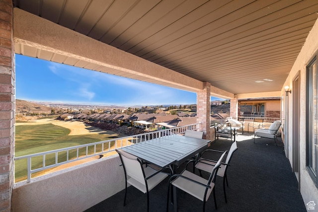 view of patio / terrace with a balcony, view of golf course, and a residential view