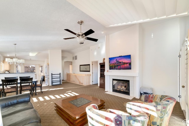 living area featuring carpet flooring, ceiling fan, vaulted ceiling, and a tiled fireplace