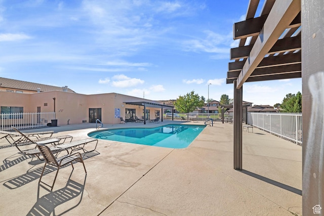 community pool with a patio and fence