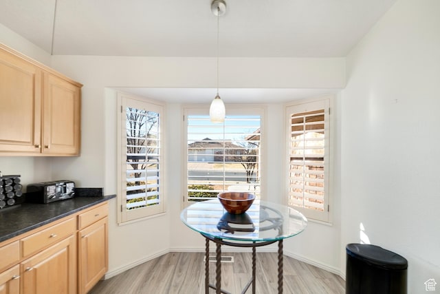 dining room featuring light wood-style flooring and baseboards