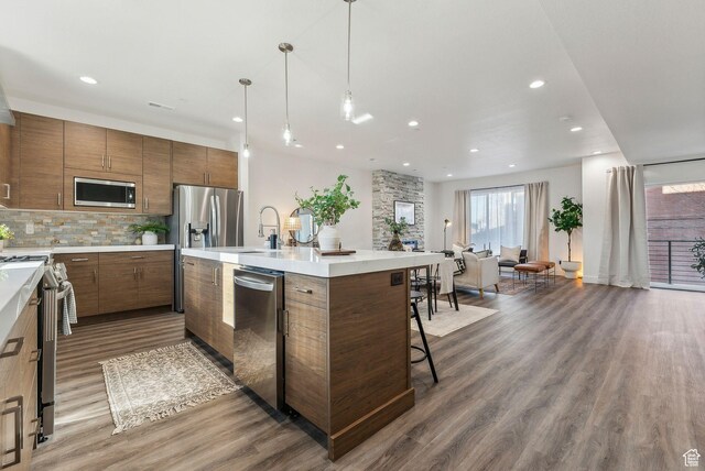 1618 S Main St Unit 2, Salt Lake City, UT 84115 - kitchen with pendant lighting, a kitchen bar, decorative backsplash, stainless steel appliances, and a center island with sink