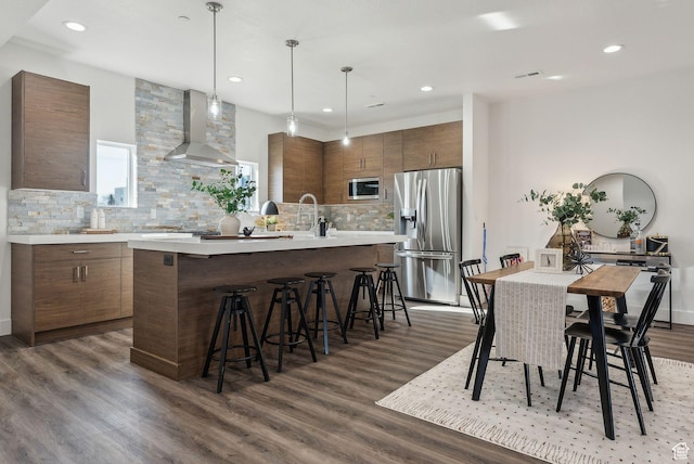 1618 S Main St Unit 2, Salt Lake City, UT 84115 - kitchen with dark wood-type flooring, wall chimney exhaust hood, pendant lighting, stainless steel appliances, and a kitchen island with sink
