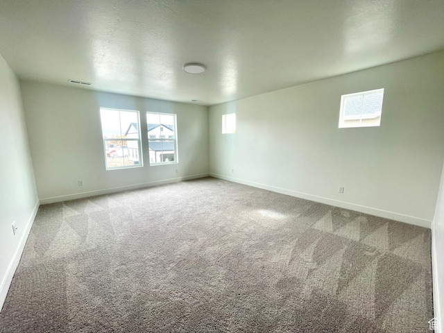 empty room featuring baseboards, carpet flooring, and visible vents