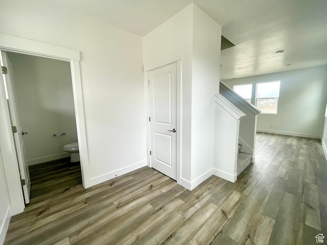 interior space with stairs, baseboards, and wood finished floors