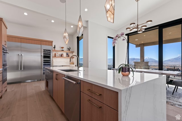 2066 E Oquirrh Mountain Cir, Heber City, UT 84032 - kitchen with light wood-type flooring, modern cabinets, a sink, a spacious island, and appliances with stainless steel finishes