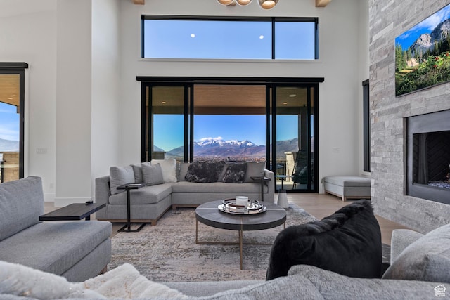 2066 E Oquirrh Mountain Cir, Heber City, UT 84032 - living area featuring a mountain view, a fireplace, a high ceiling, and wood finished floors