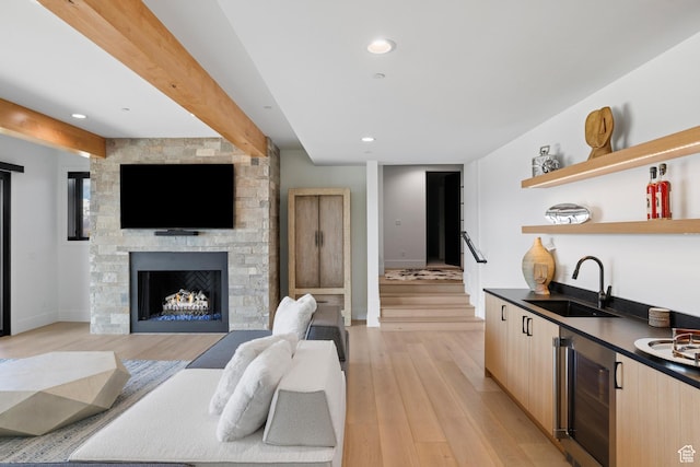2066 E Oquirrh Mountain Cir, Heber City, UT 84032 - living area with wine cooler, beamed ceiling, indoor wet bar, a stone fireplace, and light wood-style flooring