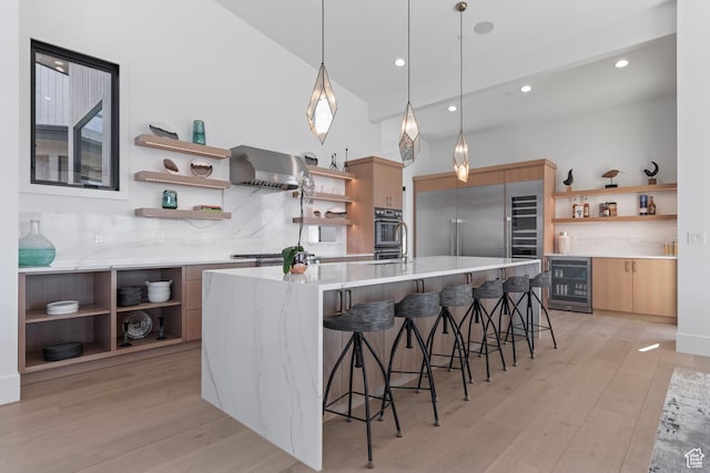 2066 E Oquirrh Mountain Cir, Heber City, UT 84032 - kitchen with wine cooler, light wood finished floors, wall chimney range hood, and open shelves