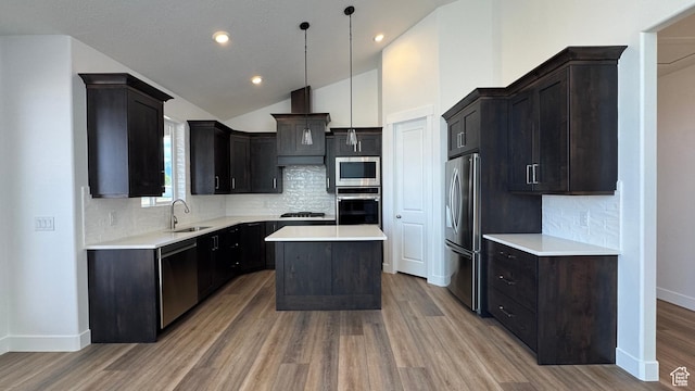 kitchen featuring appliances with stainless steel finishes, a sink, light wood-type flooring, custom exhaust hood, and vaulted ceiling