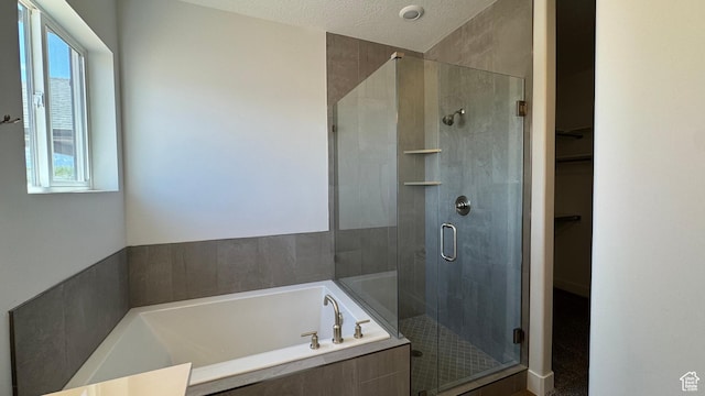 bathroom with a stall shower, a garden tub, and a spacious closet