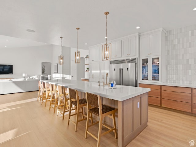 9749 N Hibiscus Ln, Eagle Mountain, UT 84005 - kitchen featuring stainless steel built in fridge, a sink, arched walkways, light countertops, and a spacious island