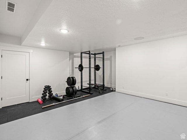 9749 N Hibiscus Ln, Eagle Mountain, UT 84005 - exercise room featuring baseboards and a textured ceiling