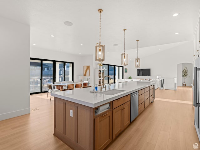 9749 N Hibiscus Ln, Eagle Mountain, UT 84005 - kitchen with open floor plan, a sink, stainless steel dishwasher, light wood-type flooring, and a large island with sink