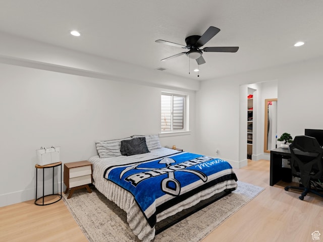 9749 N Hibiscus Ln, Eagle Mountain, UT 84005 - bedroom with light wood-type flooring, a walk in closet, recessed lighting, an office area, and ceiling fan