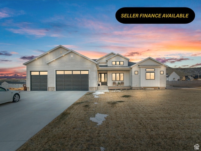 9749 N Hibiscus Ln, Eagle Mountain, UT 84005 - view of front facade featuring an attached garage, driveway, board and batten siding, and covered porch