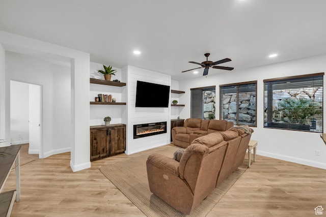235 W Golden Eagle Cir, St George, UT 84770 - living room with a large fireplace, light hardwood / wood-style flooring, ceiling fan, and built in shelves