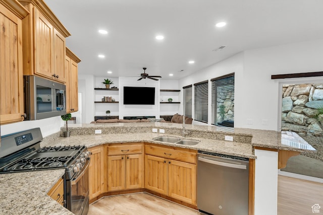 235 W Golden Eagle Cir, St George, UT 84770 - kitchen with sink, appliances with stainless steel finishes, light hardwood / wood-style floors, light stone countertops, and kitchen peninsula