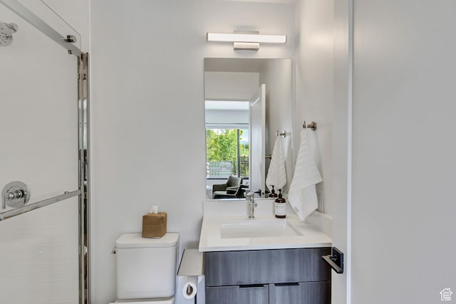 full bath with a stall shower, vanity, and toilet