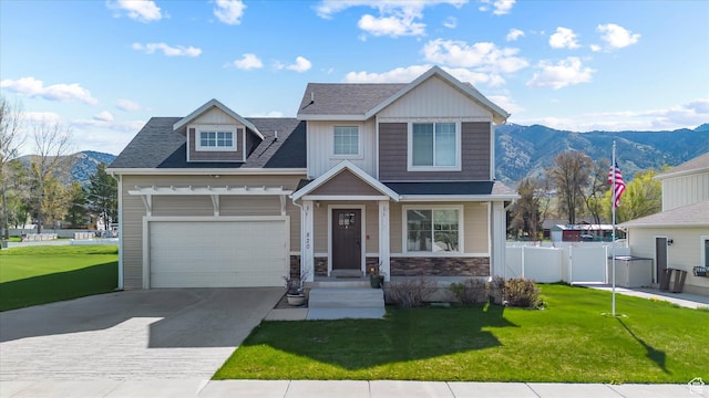 craftsman-style house featuring a mountain view, driveway, a front yard, and fence