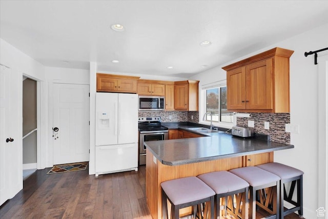 820 S 525 E, River Heights, UT 84321 - kitchen with a peninsula, dark countertops, tasteful backsplash, a sink, and appliances with stainless steel finishes
