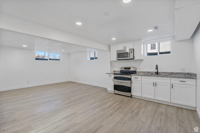 448 N 900 W, Salt Lake City, UT 84116 - kitchen with light wood-type flooring, plenty of natural light, white cabinetry, and stainless steel appliances