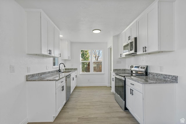 448 N 900 W, Salt Lake City, UT 84116 - kitchen with stone countertops, white cabinets, stainless steel appliances, light wood-style floors, and a sink