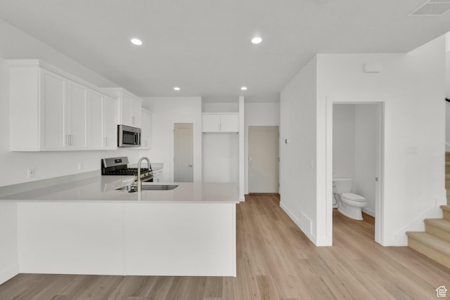 103 E 1760 N, Heber City, UT 84032 - kitchen featuring sink, white cabinetry, light hardwood / wood-style flooring, kitchen peninsula, and stainless steel appliances