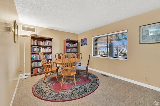 dining space with a textured ceiling and baseboards