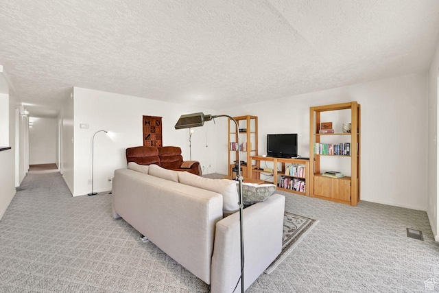 living area featuring light carpet, a textured ceiling, and baseboards