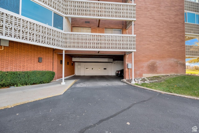 view of building exterior featuring a garage, asphalt driveway, and a carport