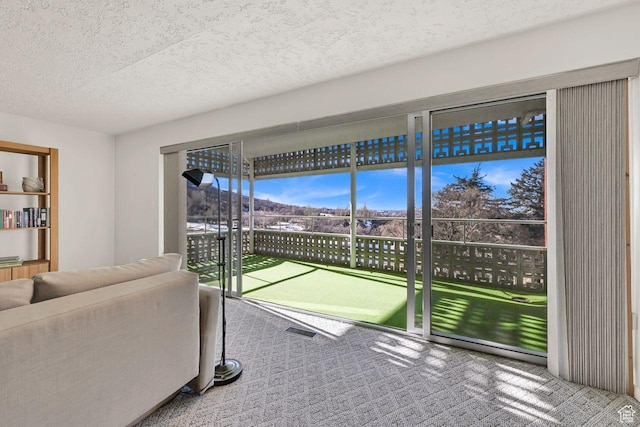 carpeted living area with a textured ceiling