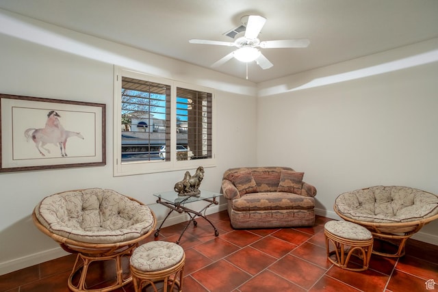 living area featuring dark tile patterned floors and ceiling fan