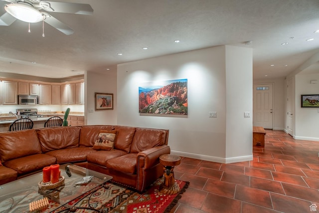 living room with sink, dark tile patterned flooring, and ceiling fan