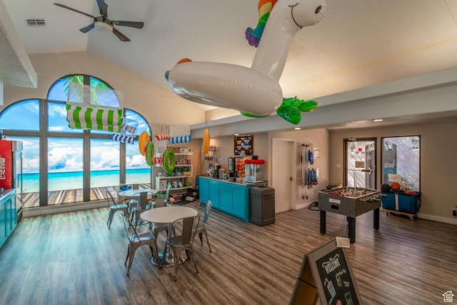 game room with dark wood-type flooring, a healthy amount of sunlight, and vaulted ceiling