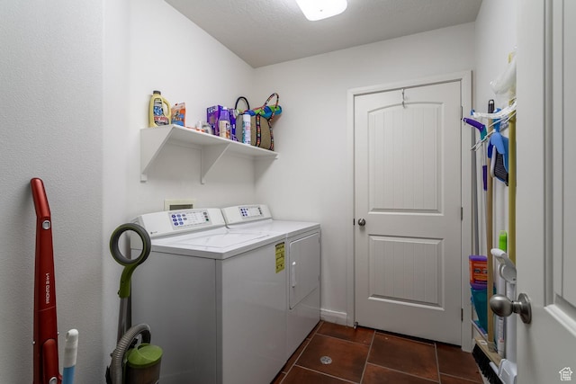 washroom featuring dark tile patterned flooring, washer and clothes dryer, and a textured ceiling