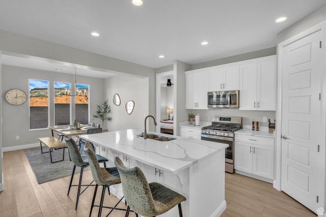 1439 N Arena Roja Dr, Washington, UT 84780 - kitchen featuring appliances with stainless steel finishes, sink, a center island with sink, and white cabinets