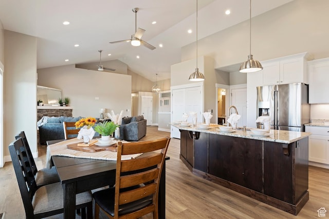 1407 N Mountain Rd, Ogden, UT 84404 - kitchen with decorative light fixtures, white cabinetry, light hardwood / wood-style floors, stainless steel fridge with ice dispenser, and a spacious island