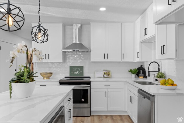 2386 E Lakeview Dr S, Millcreek, UT 84109 - kitchen featuring sink, appliances with stainless steel finishes, hanging light fixtures, white cabinets, and wall chimney exhaust hood