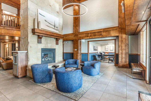 2669 Canyons Resort Dr Unit 101, Park City, UT 84098 - living room with a high ceiling, a tile fireplace, light tile patterned floors, and wood walls
