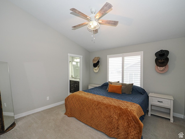 carpeted bedroom with connected bathroom, a ceiling fan, baseboards, and vaulted ceiling