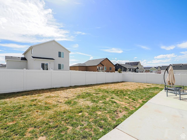 view of yard featuring a residential view, a fenced backyard, and a patio area