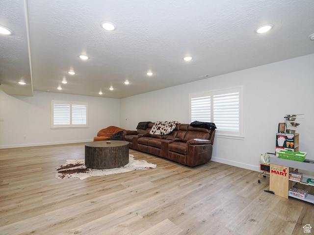 living area with recessed lighting, baseboards, a textured ceiling, and wood finished floors