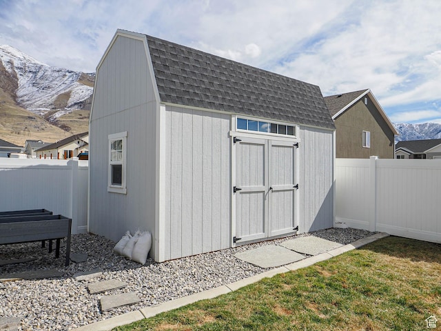 view of shed with a fenced backyard and a mountain view